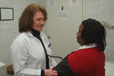 Nurse practitioner, Irene Cavall checks Sacha Pledger's blood pressure. Nurses are gaining support in their drive to play a larger primary care role. (Ron Vick/Kaiser Health News)