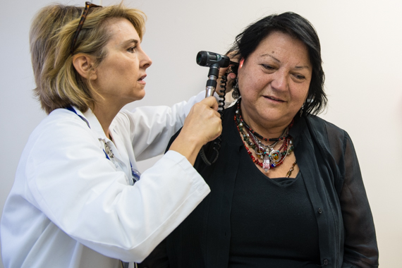 Nurse practitioner Wendy Davidson examines Teresa Martinez during an initial visit to QueensCare Health Center in Los Angeles (Photo by Heidi de Marco/KHN).