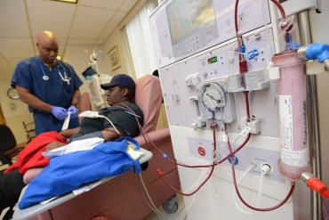 Nurse Steve Belcher, left, works with patient Antoinette Swearinger at the DaVita Downtown Dialysis Center in Baltimore in 2013. DaVita, spurred by potential growth in the market is expanding into hospital care. (AP Photo/The Daily Record, Maximilian Franz)