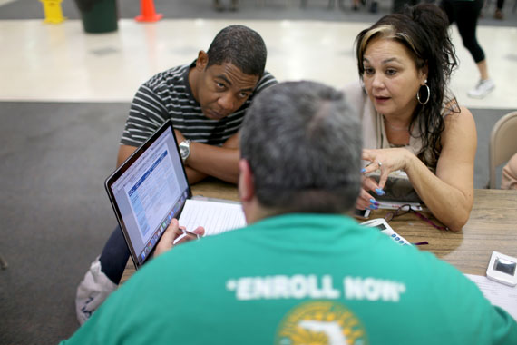 Jose Ramirez (L) and Mariana Silva speak with  Yosmay Valdivia, an agent from Sunshine Life and Health Advisors, as they discuss plans available from the Affordable Care Act at a store setup in the Mall of the Americas in Florida. (Photo by Joe Raedle/Getty Images)