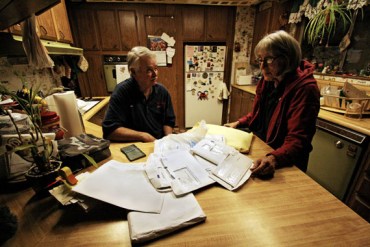 Dennie Wright and his wife Kathy go over health bills, related to care he got across the state line in Nevada. (Photo by Pauline Bartolone/Capital Public Radio)