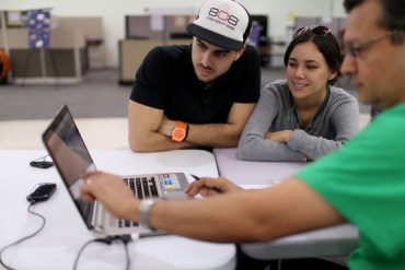 Darko Tomelic (L) and Andrea Viteri speak with Roberto Villacreses, (R) an agent from Sunshine Life and Health Advisors, as they discuss plans available from the Affordable Care Act at a store setup in the Mall of the Americas on December 15, 2014 in Miami, Florida. (Photo by Joe Raedle/Getty Images)