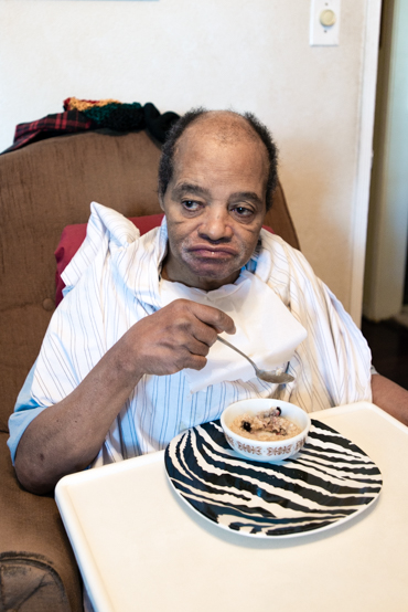 Charles Massengale can eat by himself, but needs help with everything else. The former tree trimmer has severe brain damage from a 30-foot fall, as well as dementia, diabetes and high blood pressure (Photo by Heidi de Marco).