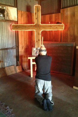 Bart Franco, 65, prays in the church he created in his backyard garage. After difficulties shopping on his own last year, Franco used a licensed broker to buy health insurance for his family in 2015. (Carrie Feibel/Houston Public Media)