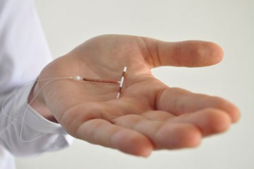 Holding an IUD birth control device in hand