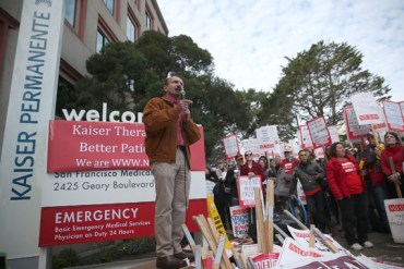 National Union of Healthcare Workers president Sal Rosselli speaks to protesters during day one of a week-long demonstration outside of Kaiser Permanente hospital on January 12, 2015 in San Francisco, California. An estimated 2,600 Kaiser mental health workers in California are staged a week-long worker strike at Kaiser hospitals thoughout the state over claims of understaffing and long appointment waits for paitents at Kaiser mental health clinics.  (Photo by Justin Sullivan/Getty Images)