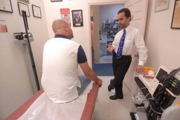 Dr. Bernd Wollschlaeger speaks to a patient at his North Miami Beach practice in 2007. Wollschlaeger, a family medicine doctor, has had to educate consumers who know little about their Affordable Care Act coverage plans while also juggling a higher patient load, more paperwork and issues with reimbursement since the passage of the act. (Photo by Peter Andrew Bosch/Miami Herald)