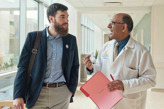 Dr. Raj Mangrulkar and medical student Jesse Burk-Rafel discuss the new medical school curriculum at the University of Michigan Medical School. (Photo by Leisa Thompson/For Kaiser Health News)