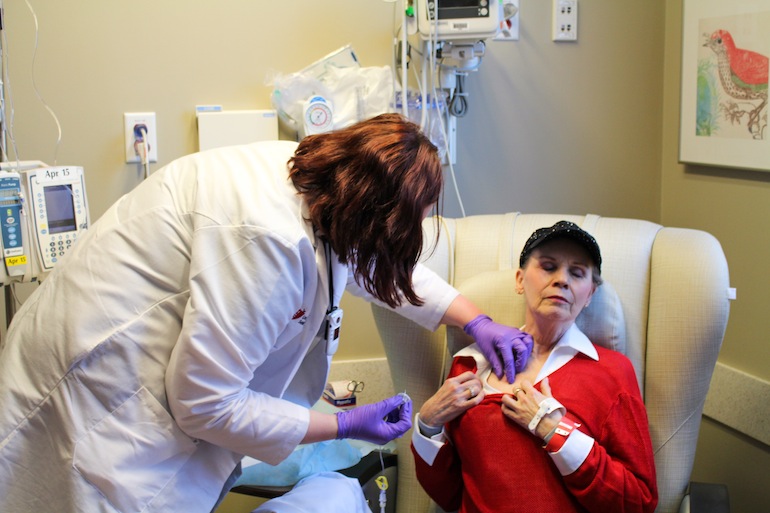 Anne Koller closes her eyes as an oncology nurse attaches an IV line of chemotherapy to a permanent port in her chest. Koller will spend 3 to 6 hours undergoing therapy (Photo by Sarah Jane Tribble/WCPN).