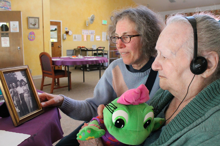 Diane Schoenfeld, left, shows a family photo to her 97-year-old aunt, Lillie Manger. (Photo by Rachel Dornhelm/KQED)