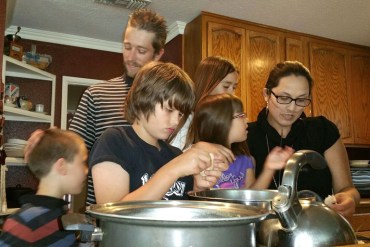 The Packer family gathers in the kitchen to cook dinner. From left: Jacob, 8; Brian Sr. ; Brian Jr., 11; Savannah, 5; Scarlett, 10; and Stephanie. (Photo by Stephanie O'Neill / KPCC)