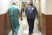 Vincent Adderly, right, a 46- year-old Miami Gardens man who is uninsured and diabetic, walks past an employee at Memorial Hospital West in Pembroke Pines on Thursday, May 28, 2015. (Photo by Marsha Halper/Miami Herald)
