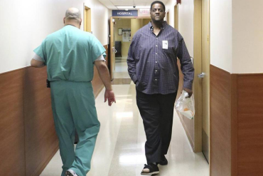 Vincent Adderly, right, a 46- year-old Miami Gardens man who is uninsured and diabetic, walks past an employee at Memorial Hospital West in Pembroke Pines on Thursday, May 28, 2015. (Photo by Marsha Halper/Miami Herald)