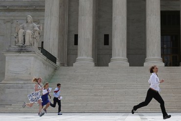Television interns run to their reporters stationed outside after being handed the ruling on the Affordable Care Act, at the  Supreme Court June 25, 2015. The high court ruled that the Affordable Care Act may provide nationwide tax subsidies to help poor and middle-class people buy health insurance.  (Photo by Mark Wilson/Getty Images)