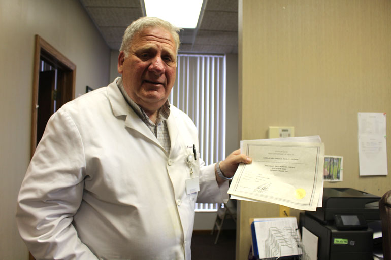 Dr. David Burkons, shows his ambulatory surgical center license that allows him to perform surgical abortions in his clinic outside Cleveland. (Photo by Sarah Jane Tribble/WCPN)