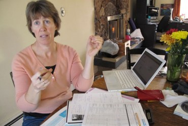 Victoria Cronquist shops for lower cost health insurance at her Anchorage home. She may drop coverage. (Photo by Annie Feidt/APRN)