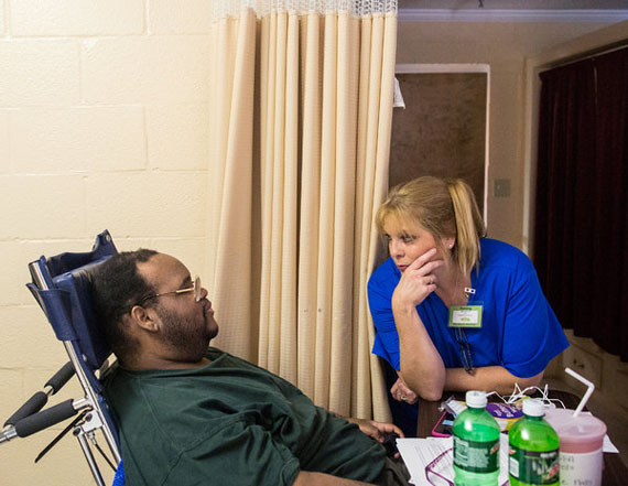 Lee Nalls talking with Kathy McCurry, a nurse. Medicaid does not reimburse nursing homes for the specialized equipment needed to care for severely obese patients. (Photo by Joe Buglewicz for The New York Times)