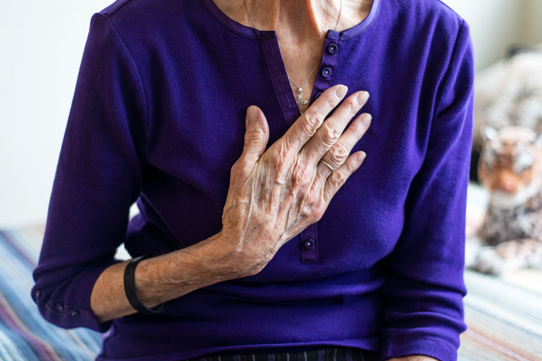 Katie Gurzi, 85, holds her chest as she recalls waking up to severe chest pains three years ago. Gurzi thought the ambulance ride to hospital was covered by her insurance, but she received a $260 bill. (Heidi de Marco/KHN)