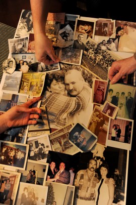 The hands of his "girls" touch a photo montage of the life of Charles Prozzillo made by his family for his memorial service. Clockwise, from left are hands of his granddaughter Chloe Kearsley, 10; daughter Ashely Kearsley; and his wife Roseann Prozzillo January 28, 2016. When Medicare stopped paying for his ambulance rides to dialysis a year ago, his family took him in their car. One day he fell and broke his hip, and died soon after. His grieving family blames the policy change. (Tom Gralish/Philadelphia Inquirer)