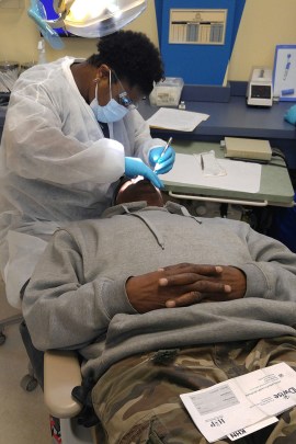 Reginald Rogers, 59, of Gary, Indiana, is examined at Kool Smiles of Gary, a dental clinic, by dentist Nicole Guyton. Rogers is in the Healthy Indiana Plan which he hopes Wil provide him with dentures. (Phil Galewitz/KHN)