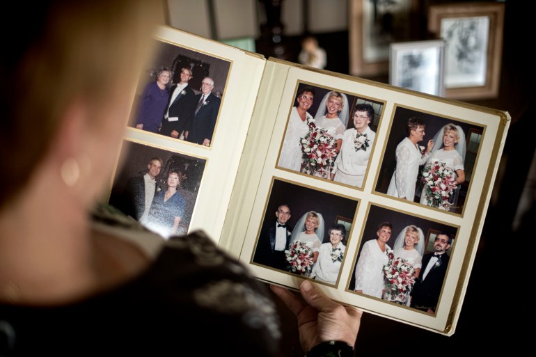 Kristin Sigg looks at wedding photos that include her mother. (Travis Young/Austin Walsh Studio for KHN)