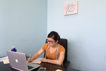 UNC Charlotte master's student Katherine Wilkin finishes notes after counseling a client. (Michael Tomsic/WFAE)