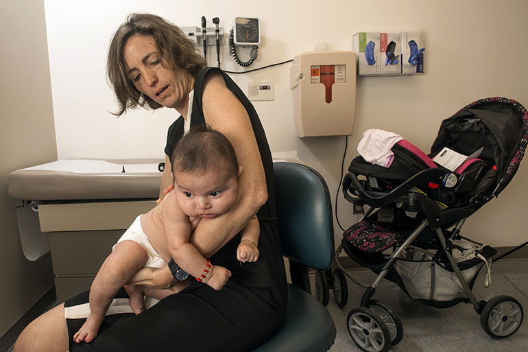Dr. Sarah Polk, a pediatrician, provides care at the Centro Sol clinic in Baltimore to patients like Janexy Marquez-Ramirez. (Doug Kapustin for KHN)