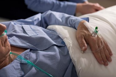 Close-up of terminally ill man's hand with drip