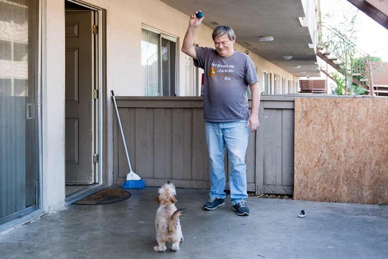 Donald Meade plays with his puppy Scrappy in his apartment patio. “If I lost this apartment, I would give Scrappy to my neighbors…I wouldn’t want him to be stressed out living in the streets.” (Heidi de Marco/KHN)