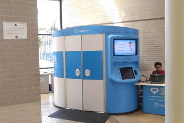 A telemedicine kiosk is outfitted with touchscreens, medical screening devices and videoconferencing capabilities in the lobby of Palm Beach County School District’s administrative building in West Palm Beach, Fla. The private, 8-by-7 enclosure enables Nicklaus Children's Hospital medical providers in Miami to see and treat adults and children in West Palm Beach. (Phil Galewitz/KHN)