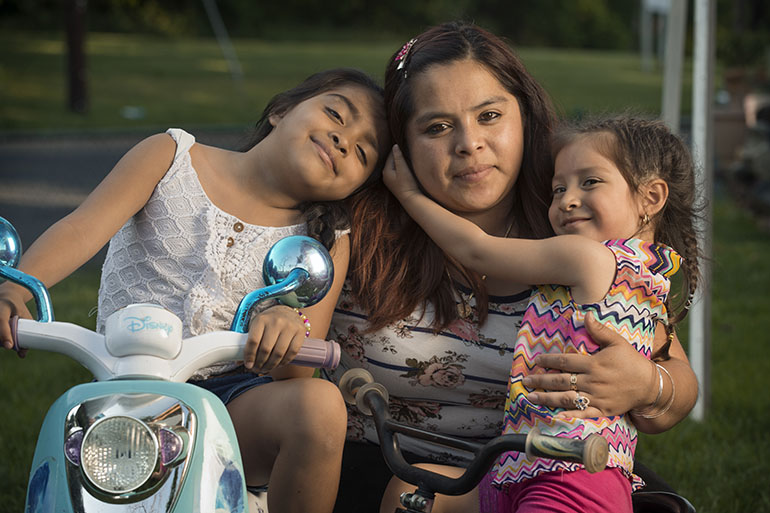 Cecilia Ramirez y sus dos hijas, Jenny Rodriguez-Ramirez, de 7 años, y Kimberly Gonzalez-Ramirez, de 3. Las niñas califican para el Medicaid porque nacieron en los Estados Unidos, pero su madre no por su status migratorio. (Doug Kapustin para KHN)