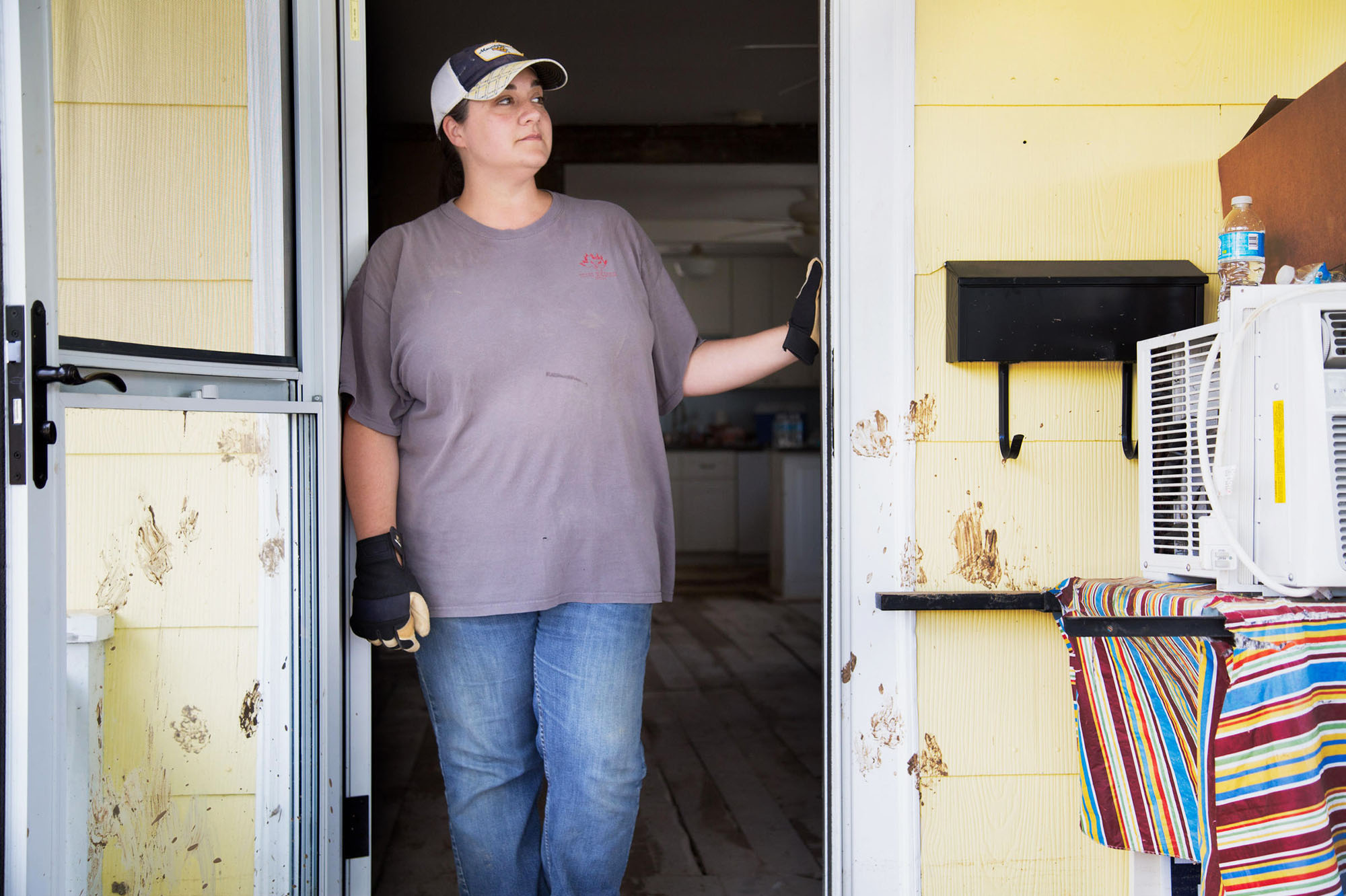 Rachel Taylor surveys the flood damage from her front porch in White Sulphur Springs, W.Va. Muddy paw prints on the front door still mark her dog's panic as the waters rose. He survived, but others didn't.
