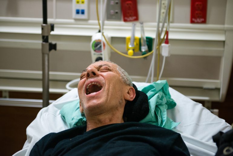 John Fornieri, 80, screams in pain as the doctor puts pressure on his hip. Fornieri, an artist with arthritis and a heart condition, was admitted to the hospital after he lost his balance and fell to the ground. (Heidi de Marco/KHN)