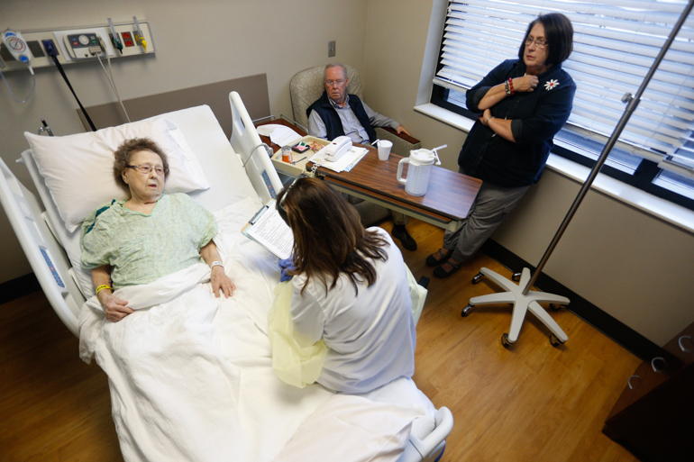 Thelma Atkins, 92, talks to Terri Middlebrooks, a nurse who manages the geriatric unit at the University of Alabama Hospital, Birmingham. Atkins’ daughter and son -in-law listen in. Middlebrooks says that “patients walk in the door of a hospital and think it’s okay to stay in a bed. It’s not.” (Hal Yeager for KHN)