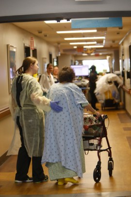 Thelma Atkins, 92, gets help walking around the geriatric unit at the University of Alabama Hospital in Birmingham. (Hal Yeager for KHN)