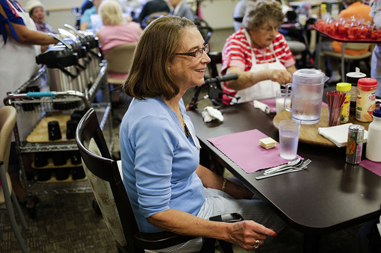 Vivian Malveaux, 81, sits down for a meal at the InnovAge center in Denver. (Nick Cote for The New York Times and Kaiser Health News)
