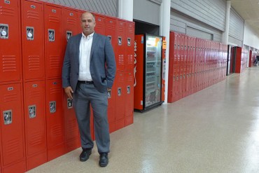 Principal John Hurley stands in front of the lockers at High Point Academy in Spartanburg, S.C. (Jenny Gold/KHN)