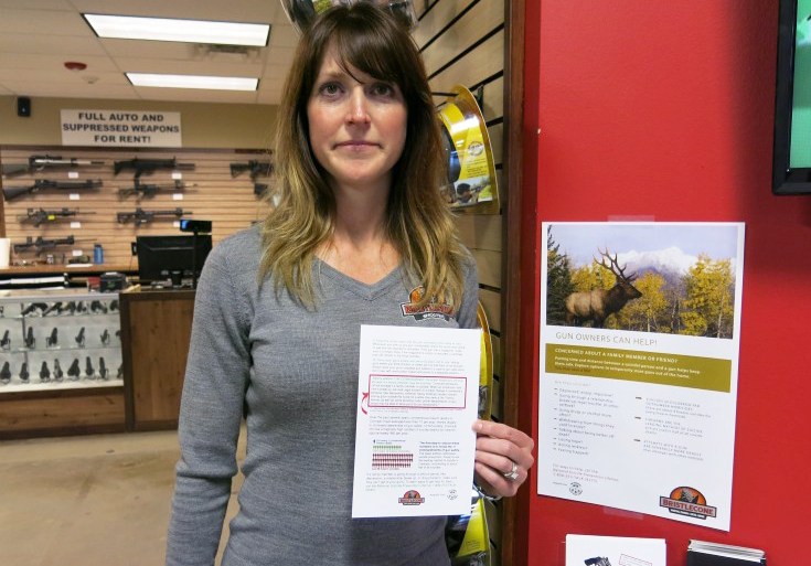 Jacquelyn Clark, co-owner of Bristlecone Shooting, Training and Retail Center in Lakewood, Colo., holds a list of gun safety rules. One recommendation: Consider "off-site storage if a family member may be suicidal." (John Daley/Colorado Public Radio)