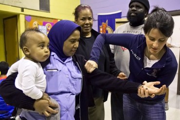 Amanda McMacken, a registered nurse at Temple University Hospital, shows North Philadelphia residents how to slow bleeding in trauma victims. (Kimberly Paynter/WHYY)