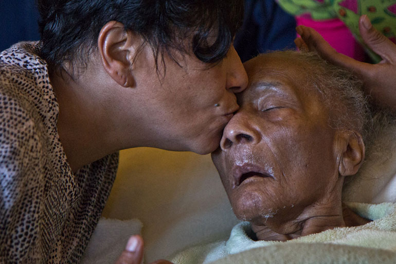 Bobo gives her mother a kiss. Her mother can't talk or move her arms or legs. (Kimberly Paynter/WHYY)