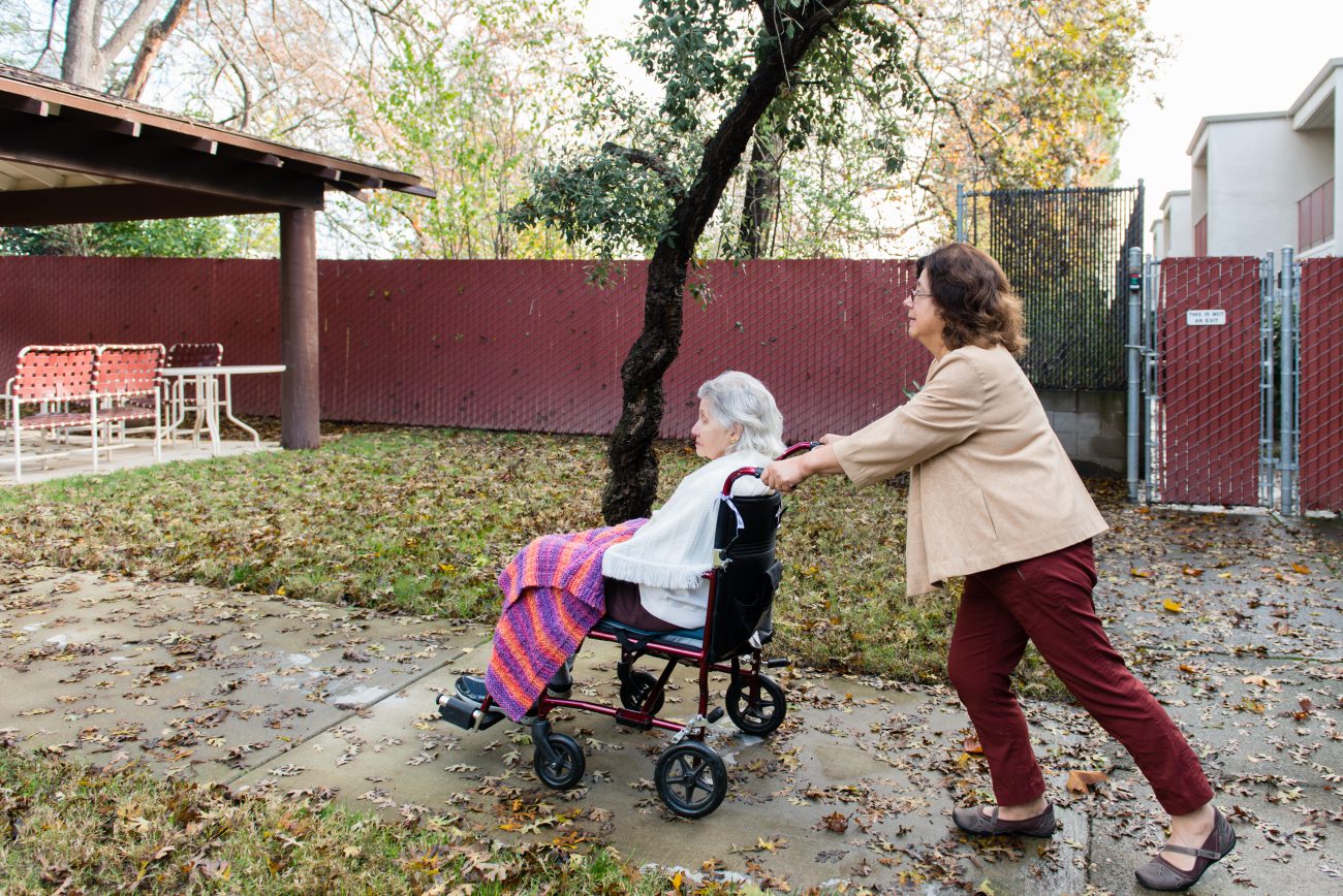 Barbara Marquez takes her mother, Florence Marquez, on a walk on Friday, December 16, 2016. (Heidi de Marco/KHN)