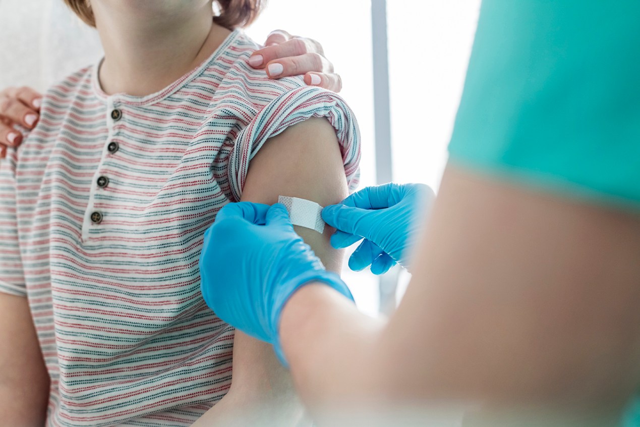 Boy in medical practice receiving band-aid