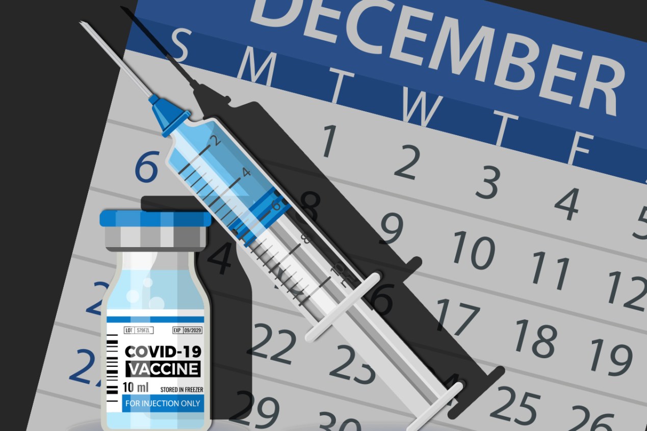 Syringe of covid-19 vaccine in front of a December 2020 calendar