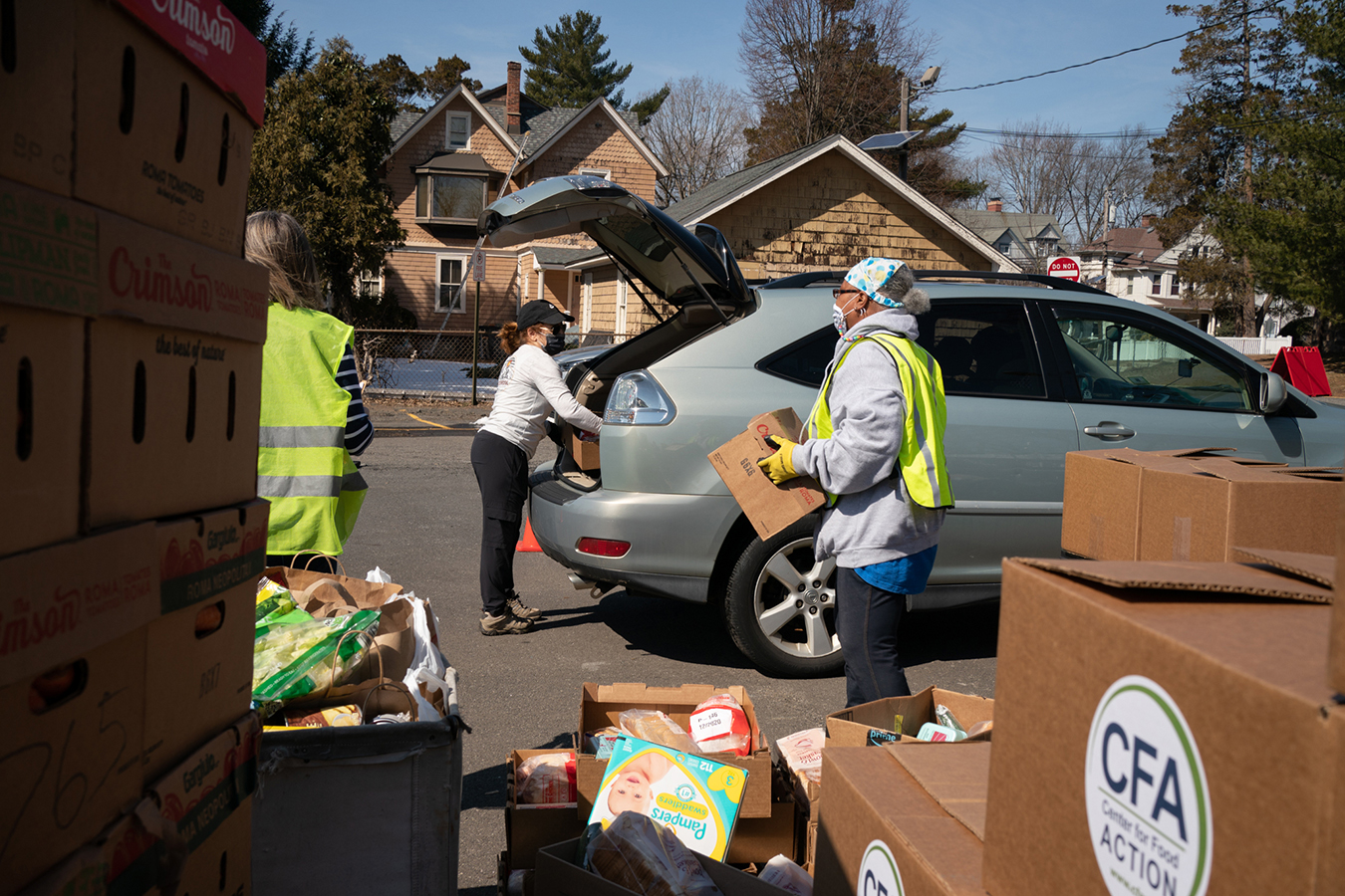 Food pantry volunteers load food into cars