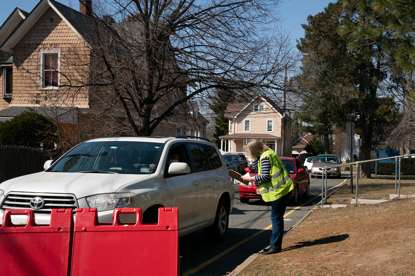 A food pantry volunteer collects information from a driver