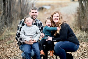 a mom, dad, young boy and young girl pose for a family photo outdoors