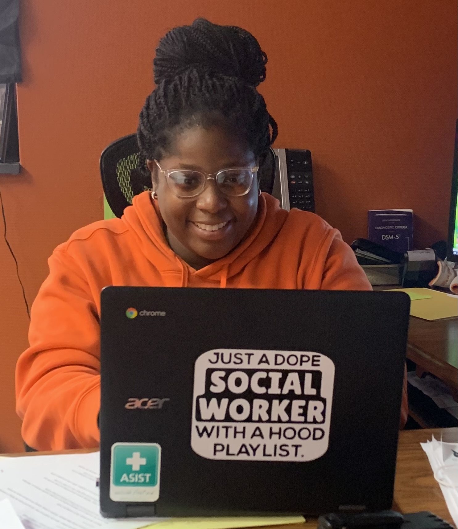 woman smiling seated in front of laptop