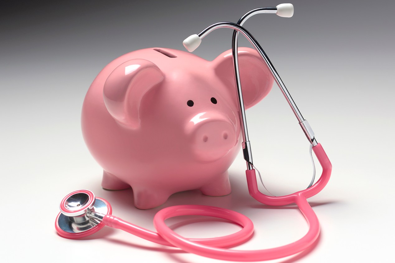 Piggy bank and a pink stethoscope
