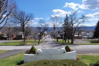 A view of Lewistown, Pennsylvania shows wide roads, buildings, a church and, in the distance, mountains.