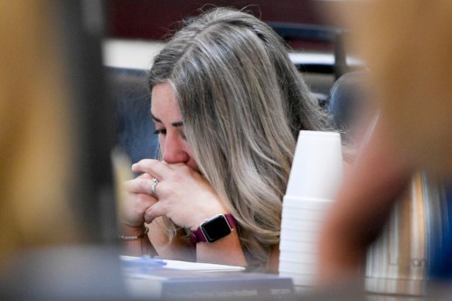 RaDonda Vaught is seen in a courtroom holding her hands to her face with her eyes closed.